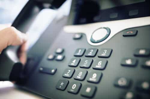 School secretary using VoIP telephone system to make outbound calls
