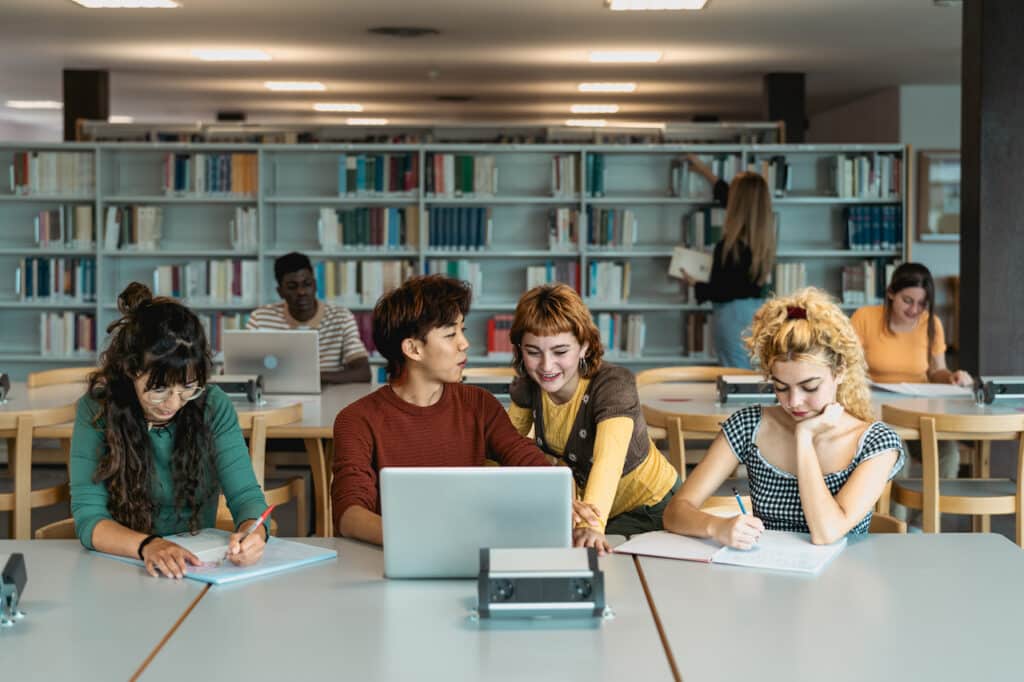 University students in the library using laptops that went through an office 365 migration